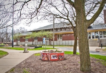 White Palmer Park building exterior with mosaic planter in foreground.